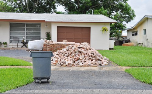 Workers clearing garden debris and loading into a van