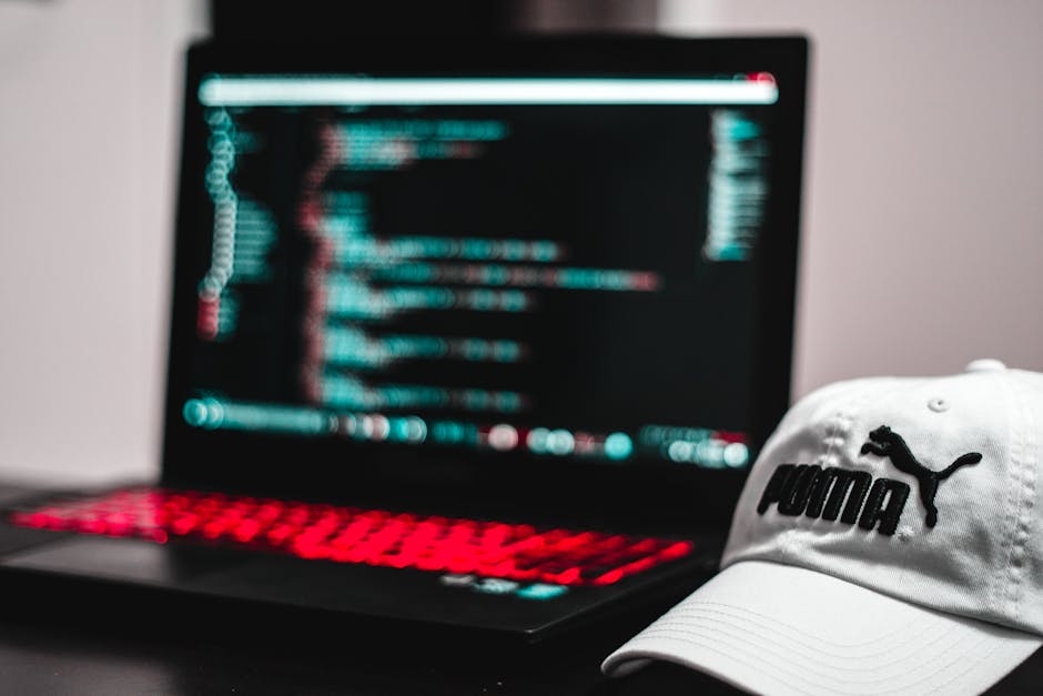 The image displays a close-up view of a computer screen with lines of code written in a text editor. The code includes HTML tags, such as <h1> and <div>, and attributes like class and alt. Visible ele